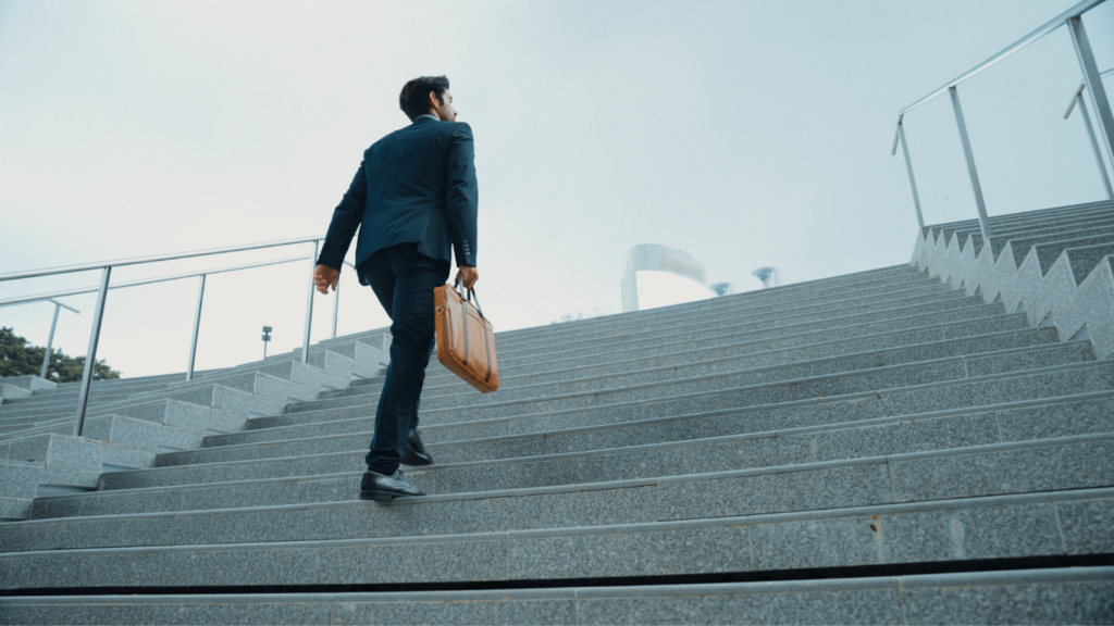 business man walking up outside office building stairs